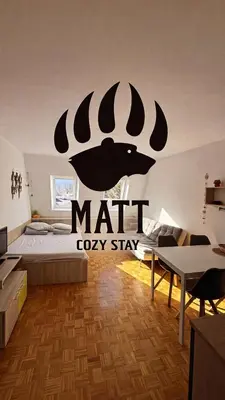 a bedroom with a bed with a mat oxify sign on the wall at MATT Cozy Stay in Bovec