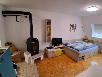 a bedroom with a bed and a wood stove at MATT Cozy Stay in Bovec