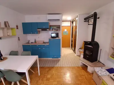 a kitchen with a table and a stove in a room at MATT Cozy Stay in Bovec