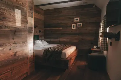 a bedroom with wooden walls and a bed in it at Domačija Majer'ca in Bohinj