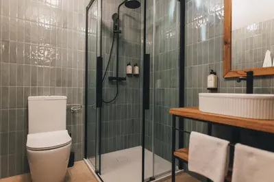 a bathroom with a shower with a toilet and a sink at Domačija Majer'ca in Bohinj