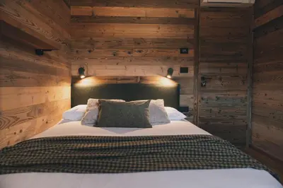 a bedroom with a large bed with wooden walls at Domačija Majer'ca in Bohinj