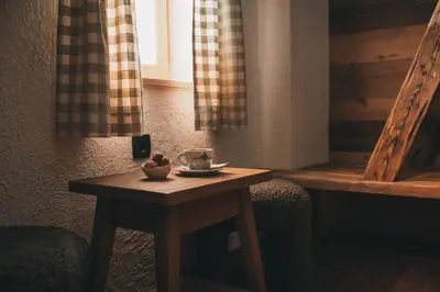 a small wooden table with a cup of coffee on it at Domačija Majer'ca in Bohinj