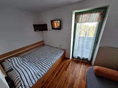 a small bedroom with a bed and a window at Apartma Ajdovka Rogla in Rakovec