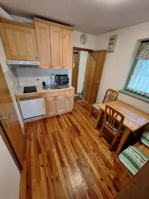 a kitchen with a wooden floor and a table at Apartma Ajdovka Rogla in Rakovec