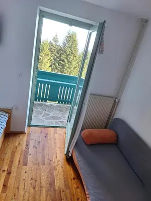 a living room with a couch and a sliding glass door at Apartma Ajdovka Rogla in Rakovec