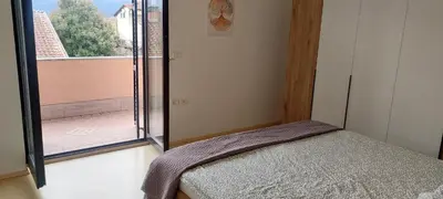 a bedroom with a bed and a large window at apartma Kiana in Šempeter pri Gorici