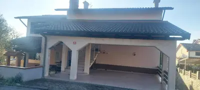 a white building with a garage with a staircase at apartma Kiana in Šempeter pri Gorici