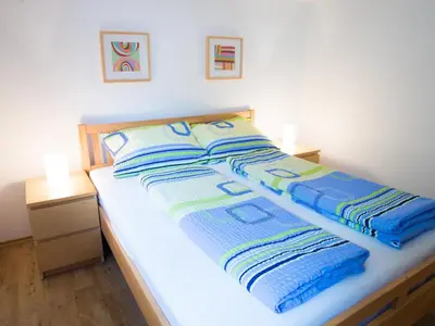 a bed with two blankets and two pillows on it at Apartment Appartement in Zasip mit Möblierter Terrasse by Interhome in Bled