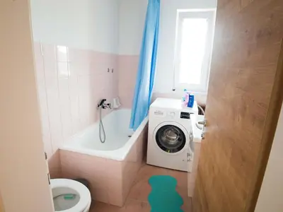a bathroom with a washing machine and a toilet at Apartment Tolle Ferienwohnung in Zasip mit Parkplatz by Interhome in Bled