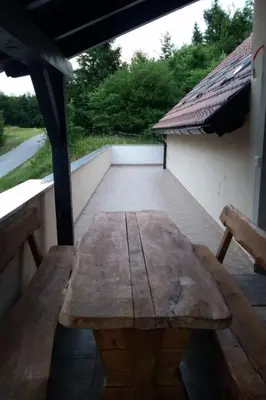 a wooden table on the back of a porch at Apartment für 4 Personen ca- 60 m² in Gozd- Krain - Innerkrain by Interhome in Gozd