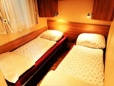 a small room with two twin beds in it at Apartment Stacaravan Rozika Slowenien by Interhome in Slovenj Gradec