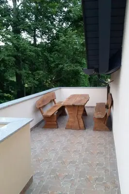 two wooden benches sitting on a patio next to a wall at Apartment Studio für 4 Personen ca- 106 m² in Gozd- Krain - Innerkrain by Interhome in Gozd