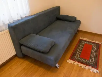 a gray couch in a living room at Apartment Kleines Haus am Rande des Waldes by Interhome in Kranj