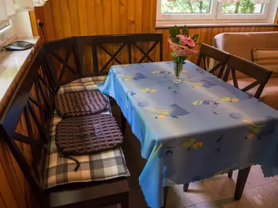 a table with a blue table cloth with a vase on it at Apartment Kleines Haus am Rande des Waldes by Interhome in Kranj