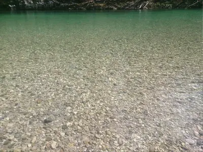 a large body of water with rocks in it at Apartment Wohnung Lapanja 2 mit Gemeinschaftsgarten by Interhome in Slappe dʼIdria