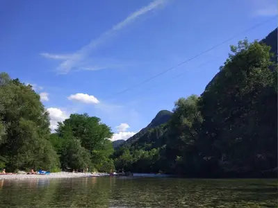 a body of water with trees and a mountain at Apartment Wohnung Lapanja 2 mit Gemeinschaftsgarten by Interhome in Slappe dʼIdria
