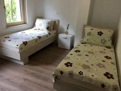 a small bedroom with two beds and a window at Apartment Wohnung Lapanja 2 mit Gemeinschaftsgarten by Interhome in Slappe dʼIdria