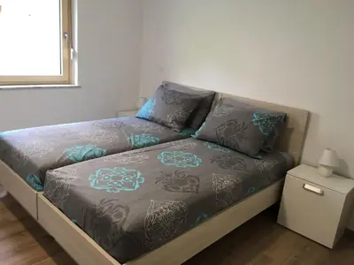 a bed in a room with a couch with pillows at Apartment Wohnung Lapanja 2 mit Gemeinschaftsgarten by Interhome in Slappe dʼIdria