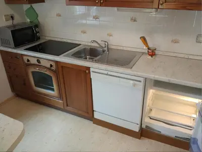 a kitchen with a sink and a stove and a microwave at Apartment mit eigener Sonnenterrasse by Interhome in Slappe dʼIdria