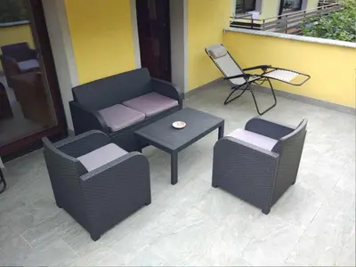 a patio with a couch and a table and a chair at Apartment mit eigener Sonnenterrasse by Interhome in Slappe dʼIdria