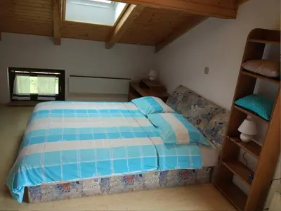 a bedroom with a bed with a blue and white comforter at Apartment mit eigener Sonnenterrasse by Interhome in Slappe dʼIdria