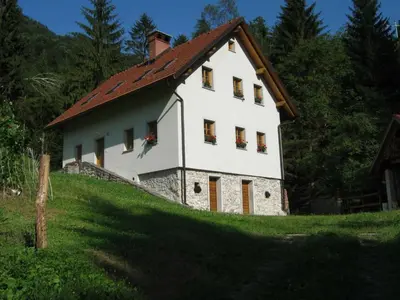 a white house with a red roof on a hill at Holiday Home Geräumiges Ferienhaus inmitten der Natur by Interhome in Dolenja Trebuša