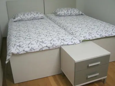 a bed with a dresser and a white bedspread at Holiday Home Geräumiges Ferienhaus inmitten der Natur by Interhome in Dolenja Trebuša