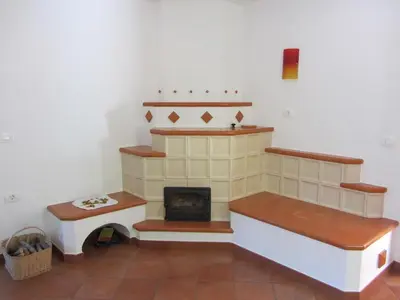 a living room with a fireplace and a stove at Holiday Home Geräumiges Ferienhaus inmitten der Natur by Interhome in Dolenja Trebuša