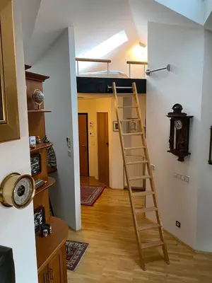 a room with a ladder and a clock on the wall at Apartment Loft in Ljubljana