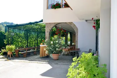 an outdoor patio with tables and flowers in a building at Guest House Gostišče Jutriša in Rogatec
