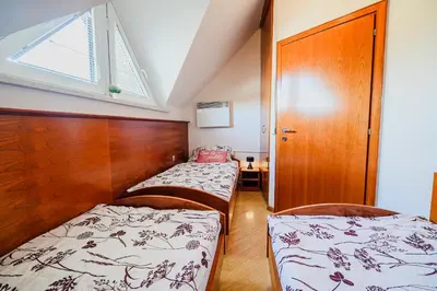 two beds in a small room with a window at Casa Termalis in Terme Čatež in Brežice