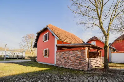 a red house with a roof and a tree at Casa Termalis in Terme Čatež in Brežice