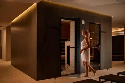 a woman in a white dress walking in front of a mirror at Casa Termalis in Terme Čatež in Brežice