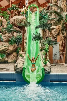 a woman riding a water slide at a resort at Casa Termalis in Terme Čatež in Brežice