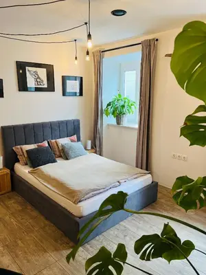 a bedroom with a bed and a potted plant at Sweetheart Apartment in Ljubljana