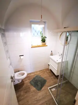 a bathroom with a toilet and a sink and a window at Sweetheart Apartment in Ljubljana