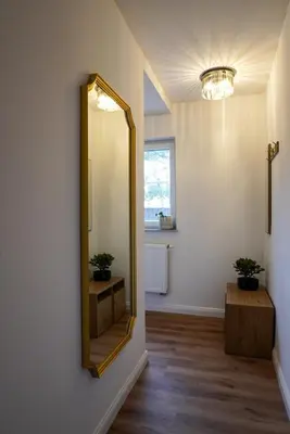 a mirror on a wall in a room with a table at Emmas apartment with private parking and balcony in Ljubljana