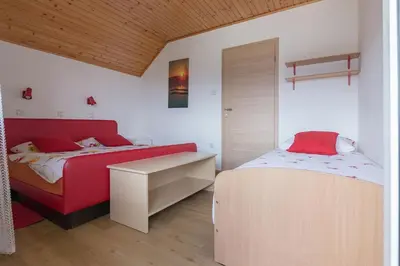 a bedroom with two beds and a desk in it at Apartma Žvan in Bled