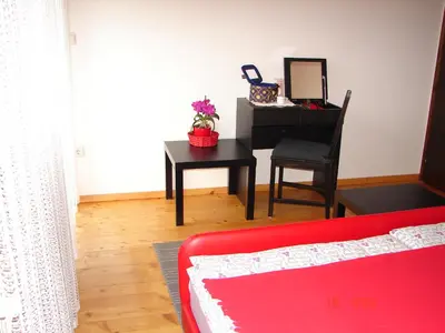 a living room with a red couch and a piano at Apartma Žvan in Bled