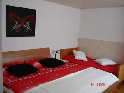 two beds in a bedroom with red and white at Apartma Žvan in Bled