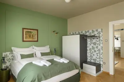 a bedroom with a large bed with green walls at Franz Apartments in Ilirska Bistrica
