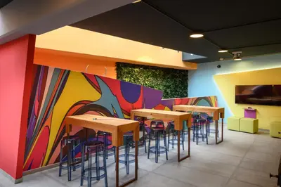 a restaurant with tables and chairs and a colorful wall at Franz Apartments in Ilirska Bistrica