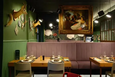 a restaurant with two tables and a painting on the wall at Franz Apartments in Ilirska Bistrica