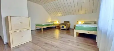 a room with two beds and a dresser in it at Pr Pogorev in Begunje na Gorenjskem
