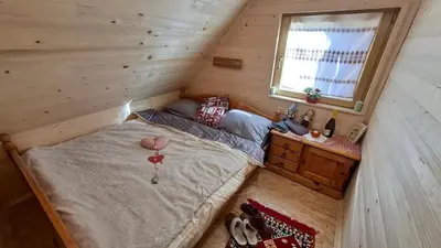 a small bedroom with a bed and a window at Cabin on Kobilica Off Grid Alpine Eco Retreat with Stunning Views Trail access only hike&bike in Tržič