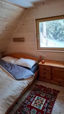 a bedroom with a bed and a window and a rug at Cabin on Kobilica Off Grid Alpine Eco Retreat with Stunning Views Trail access only hike&bike in Tržič