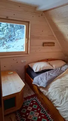 two beds in a room with a window at Cabin on Kobilica Off Grid Alpine Eco Retreat with Stunning Views Trail access only hike&bike in Tržič