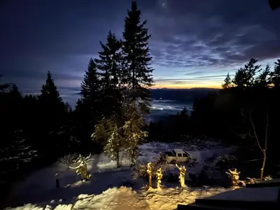 a christmas tree in the snow at night at Cabin on Kobilica Off Grid Alpine Eco Retreat with Stunning Views Trail access only hike&bike in Tržič