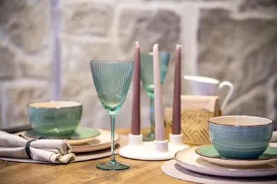 a table with candles and plates and glasses on it at Apartment Angel's Nest with Sauna and Fitness in Jesenice
